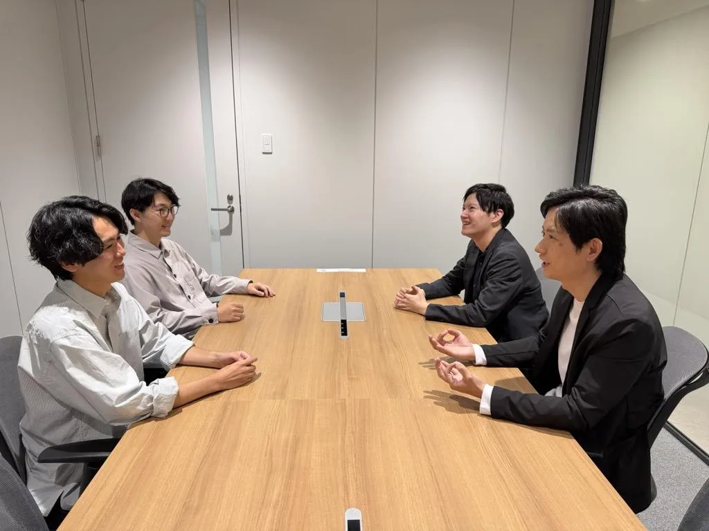足利銀行とCINCAの担当者4名が向かい合って話す様子